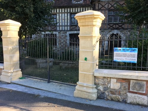 grand portail noir en fer forge avec piliers